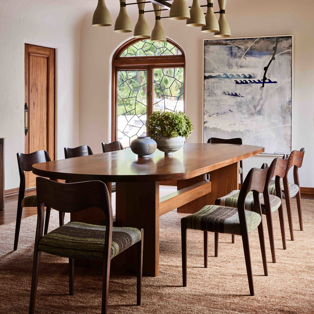 a dining room with a large wooden table surrounded by chairs