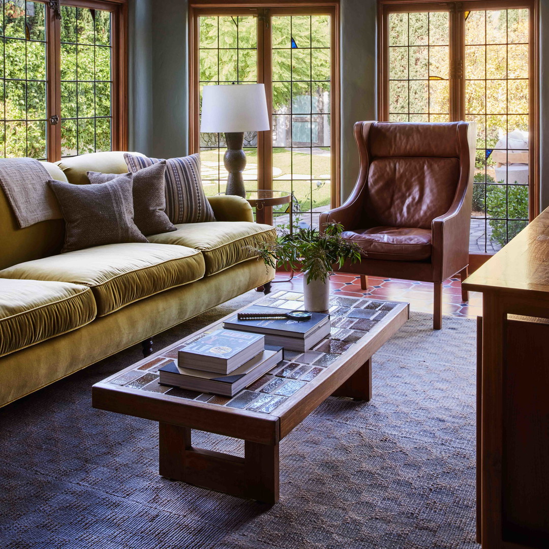 a living room filled with furniture and large windows