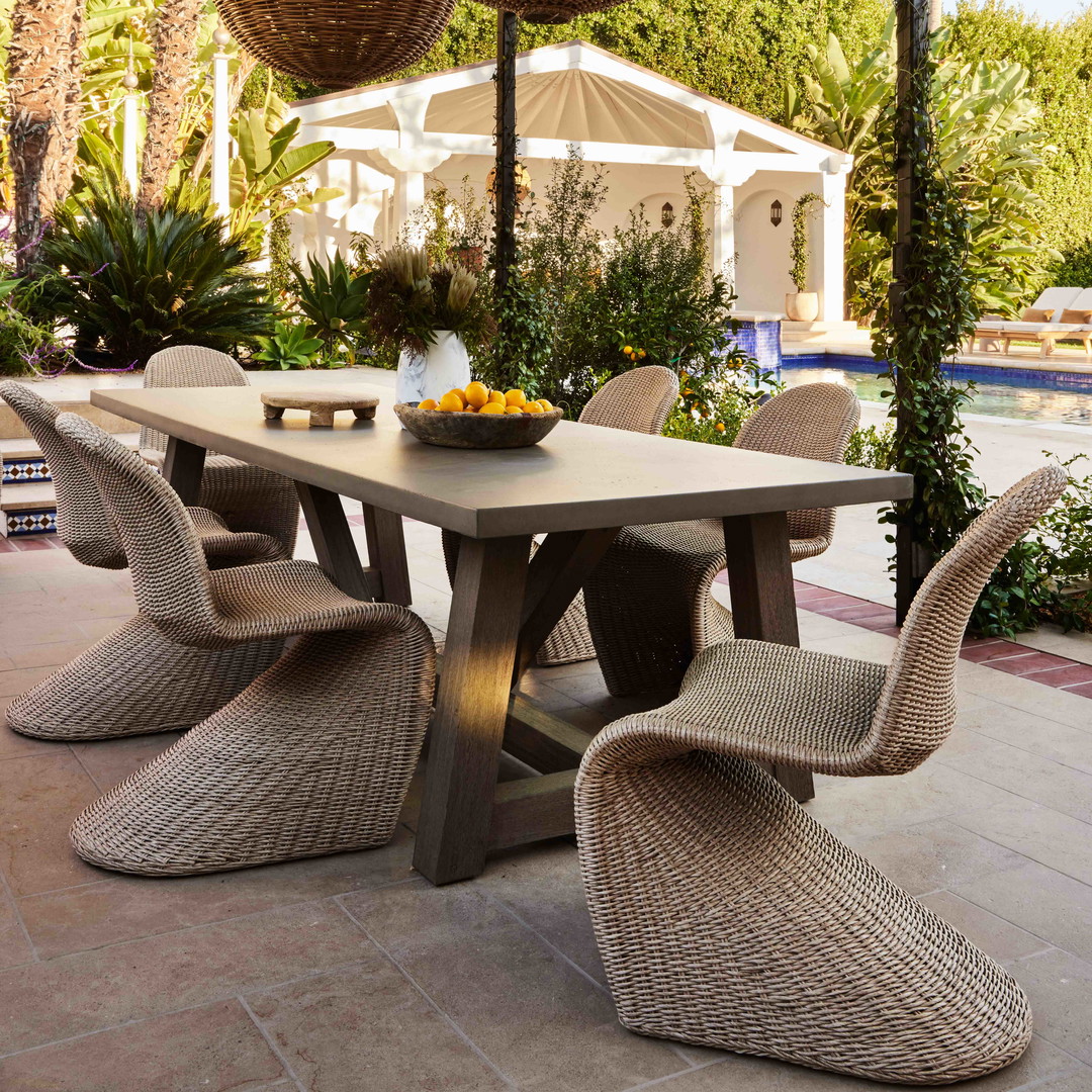 a table with chairs and a bowl of fruit on it