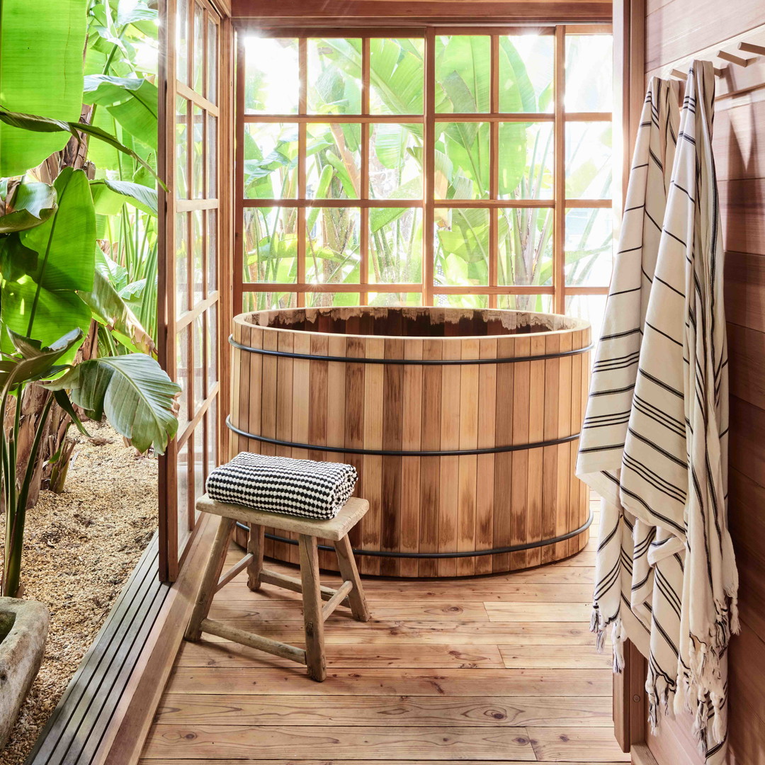 a large wooden hot tub sitting inside of a bathroom