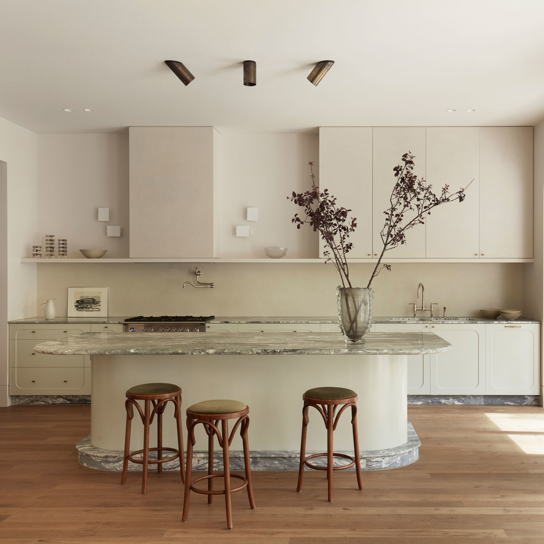 a large kitchen with a center island and three stools