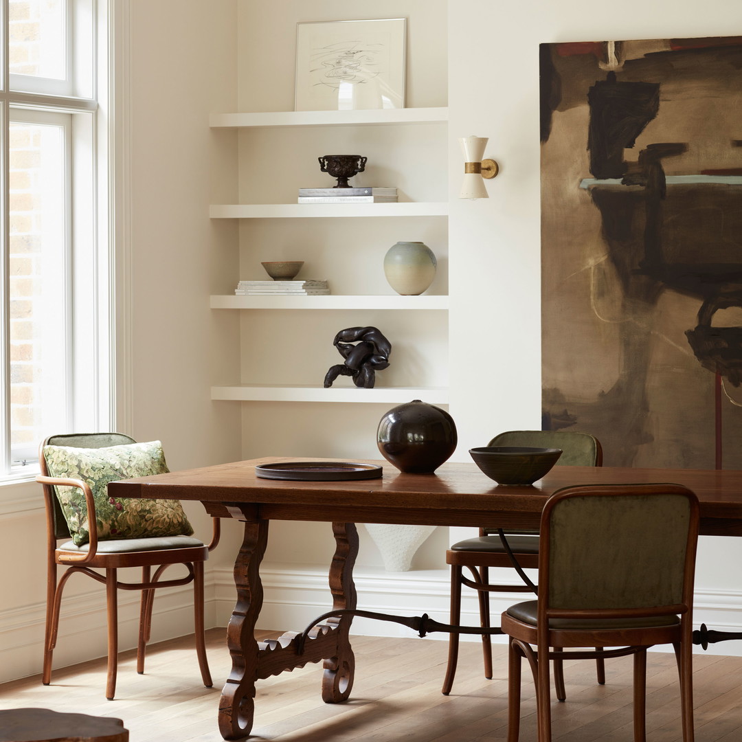 a dining room with a large painting on the wall