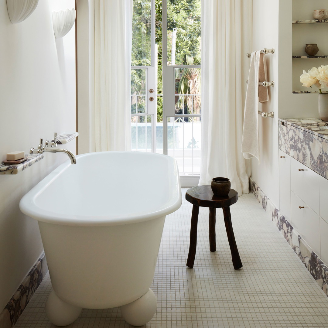 a large white bath tub sitting next to a window