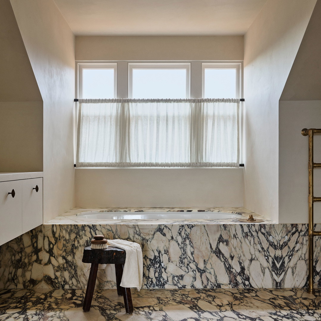 a bathroom with a marble bathtub and a window