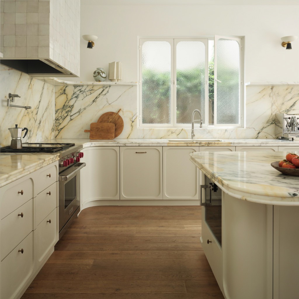 a kitchen with a marble counter top and white cabinets