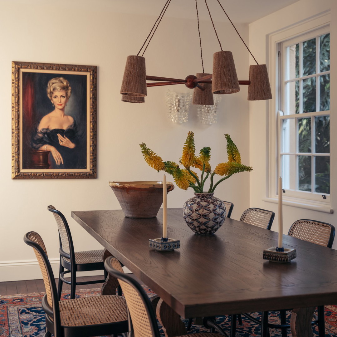 a dining room table with a vase of flowers on it