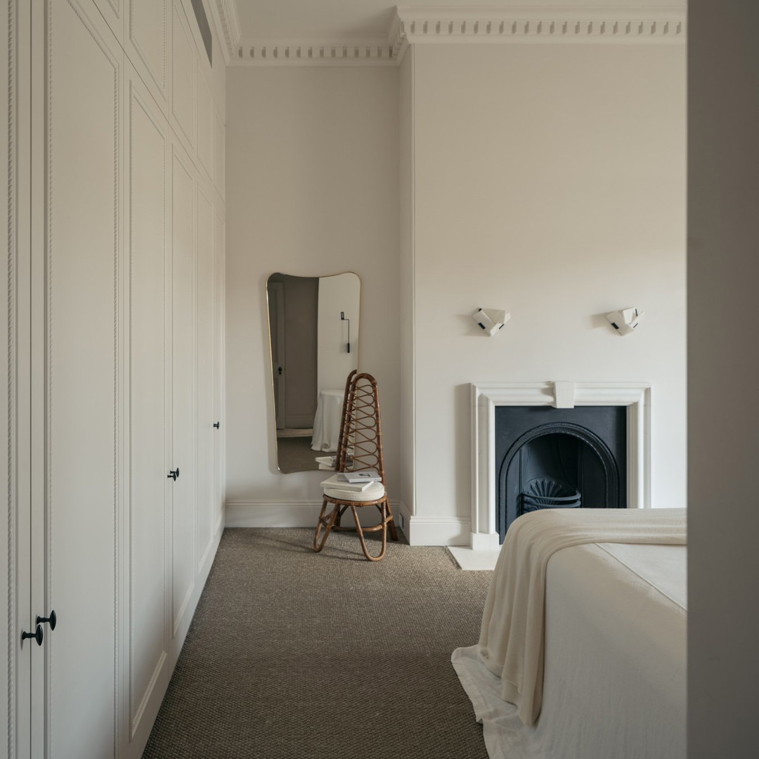 a bedroom with a fireplace and white walls