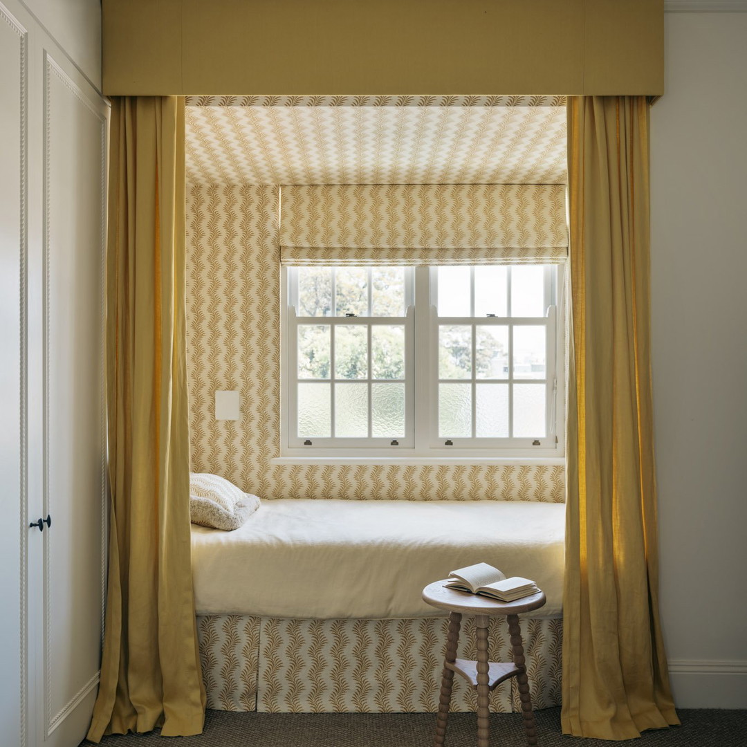 a bedroom with yellow curtains and a white bed