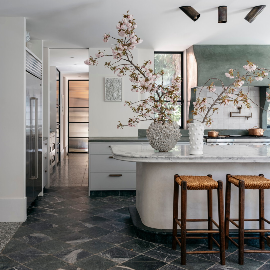 a kitchen with a marble counter top and two stools