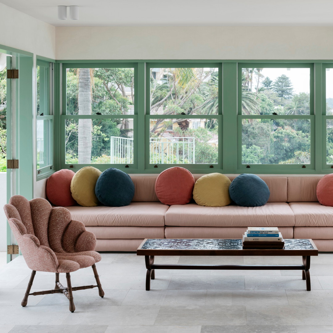 a living room filled with furniture and large windows