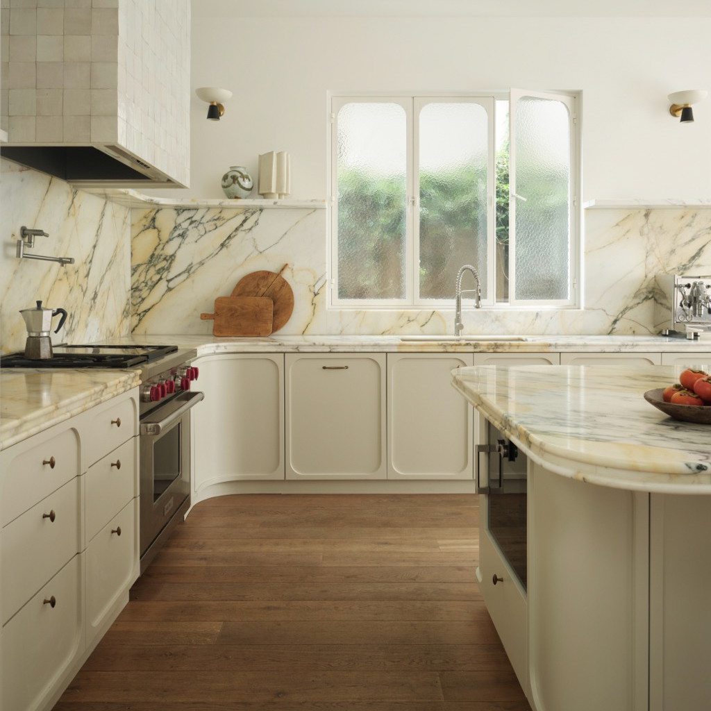 a kitchen with a marble counter top and white cabinets