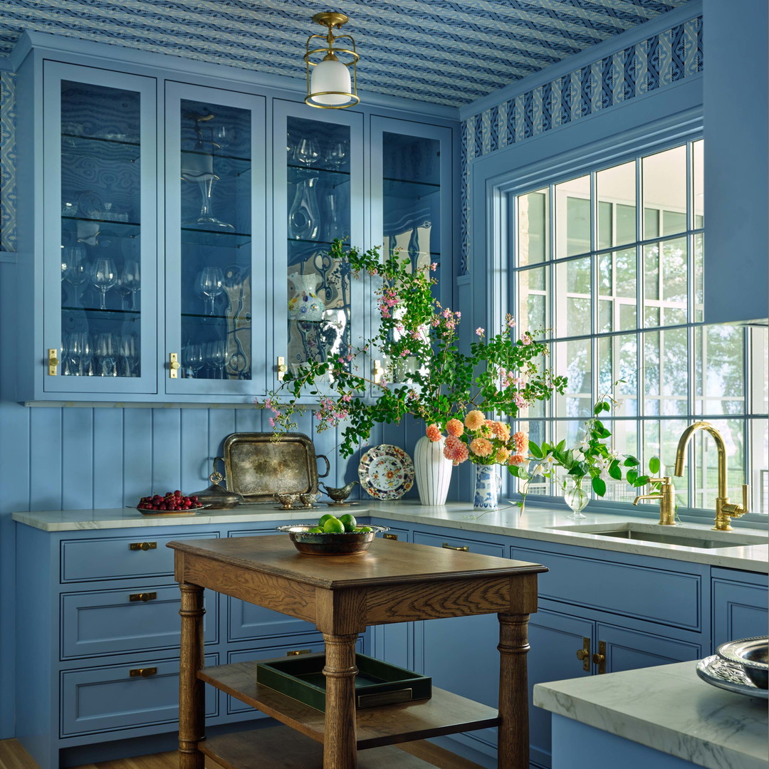 a kitchen with blue cabinets and a wooden table