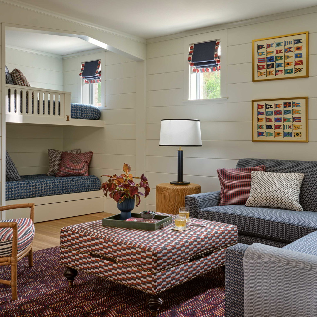 a living room with a couch, chair, ottoman and bunk bed