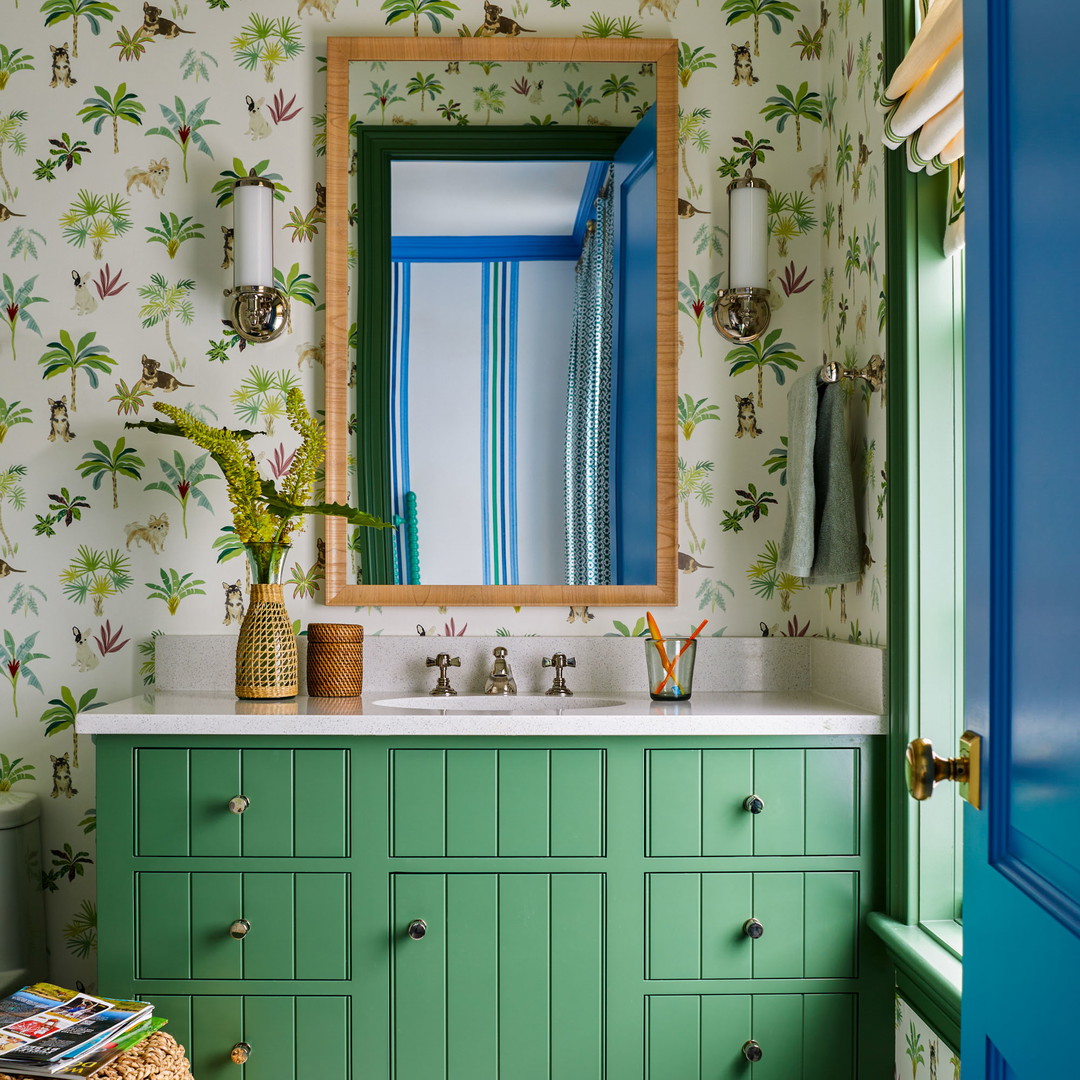 a bathroom with a palm tree wallpaper and green cabinets