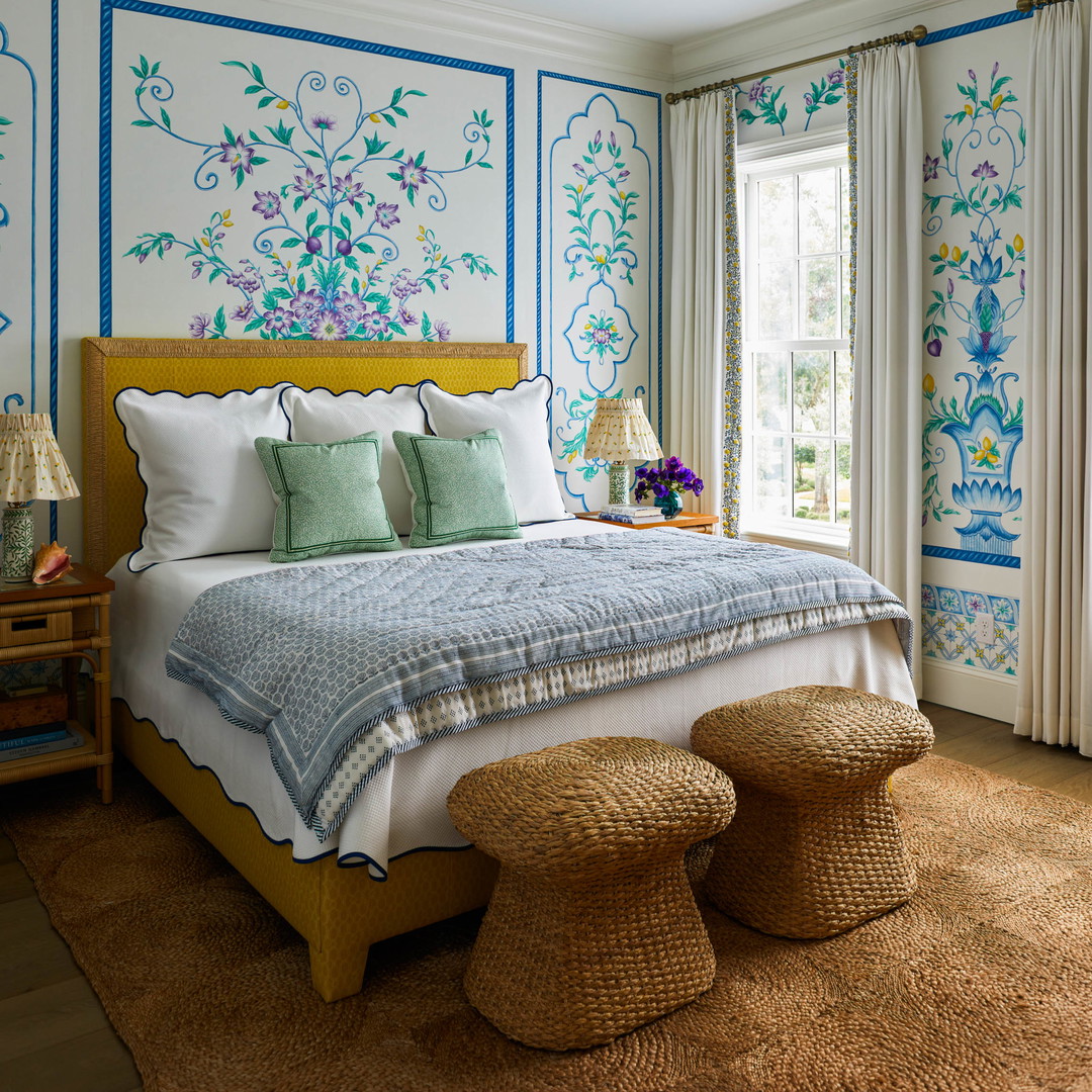 a bedroom with a large bed and blue and white wallpaper