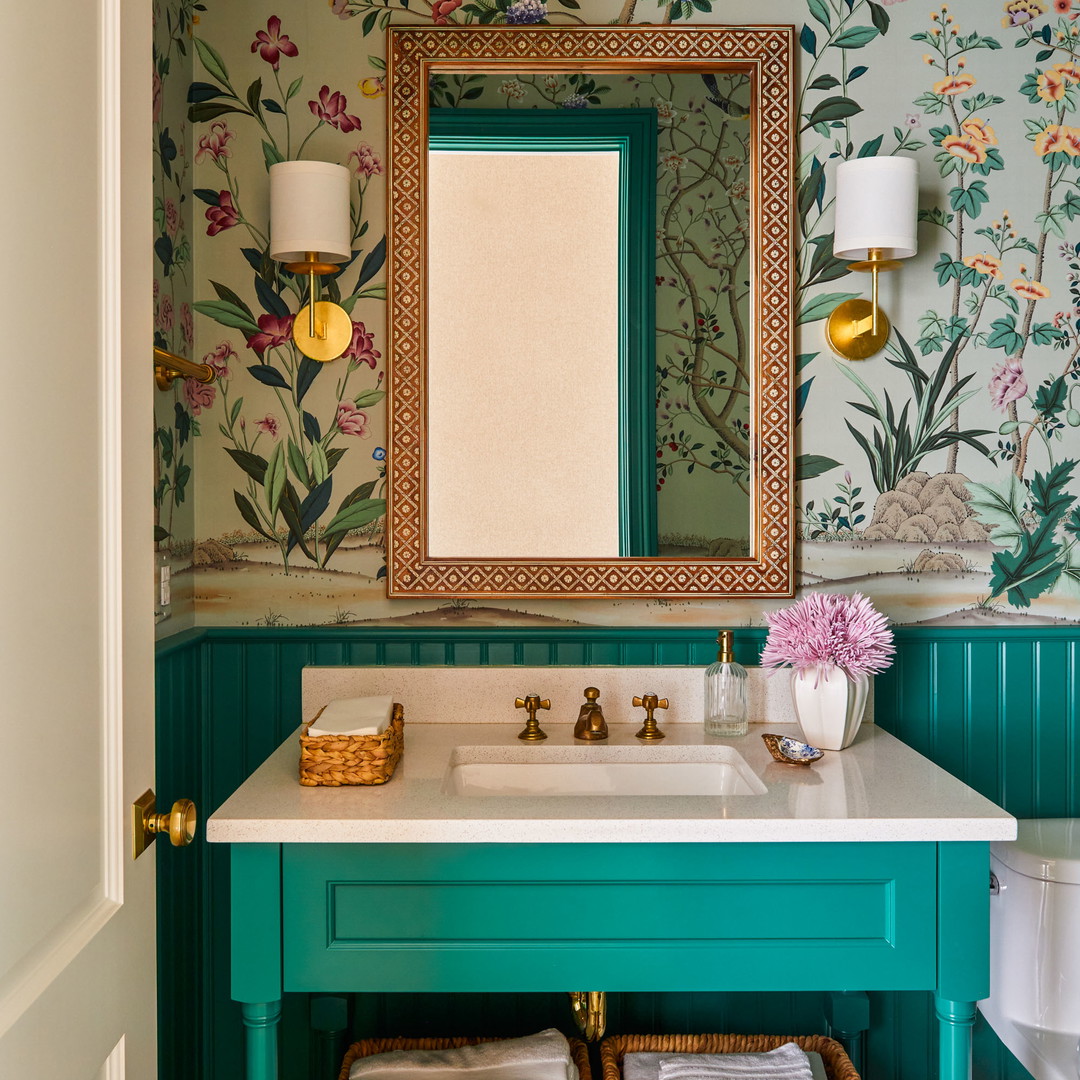 a bathroom with a green vanity and floral wallpaper