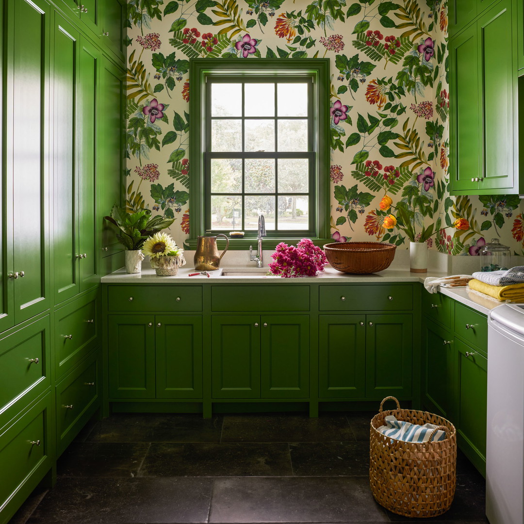 a kitchen with green cabinets and floral wallpaper