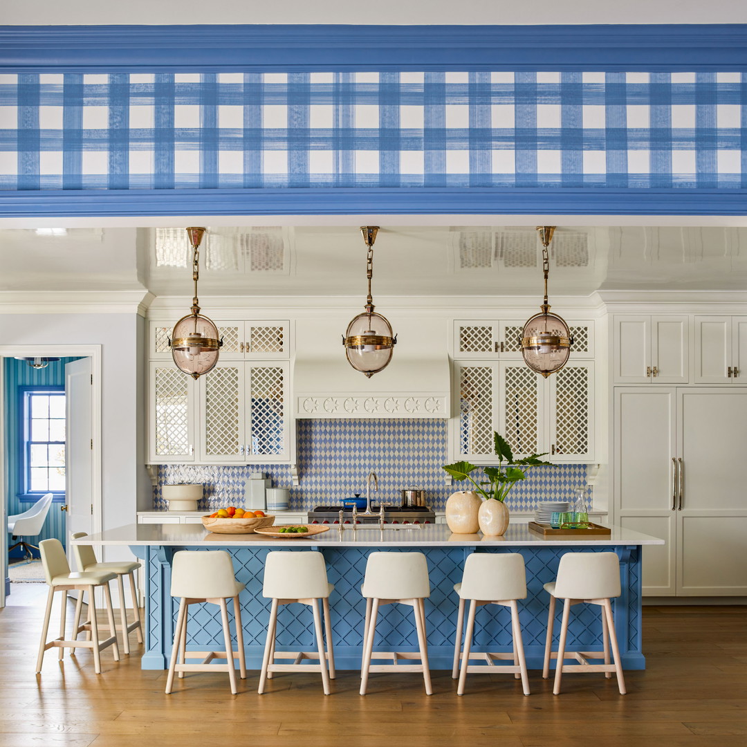 a kitchen with a blue island and white chairs