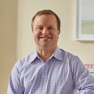 a man standing next to a chair in a living room