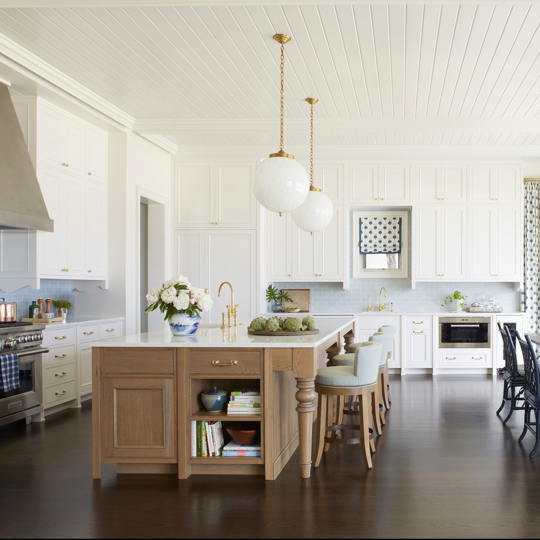 a large kitchen with a center island with chairs