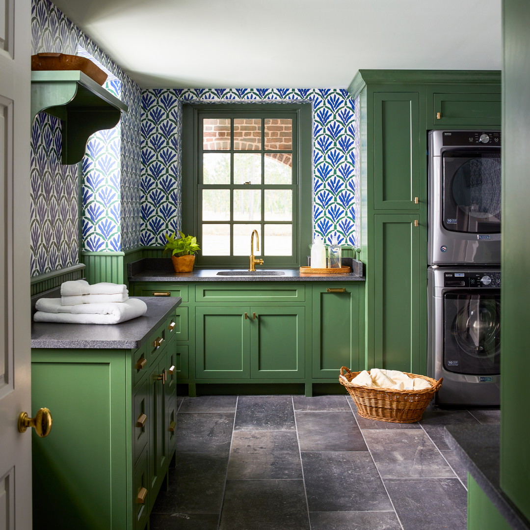 a kitchen with green cabinets and tile flooring