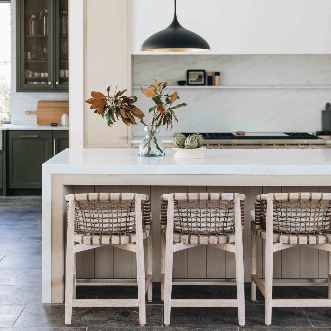 a kitchen with a white counter top and chairs