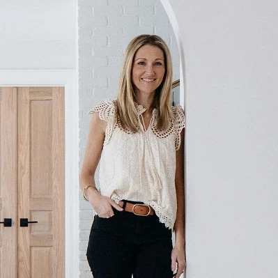 a woman standing in a living room next to a doorway