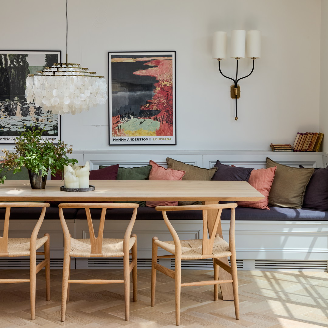 a room with a couch, table, chairs and pictures on the wall