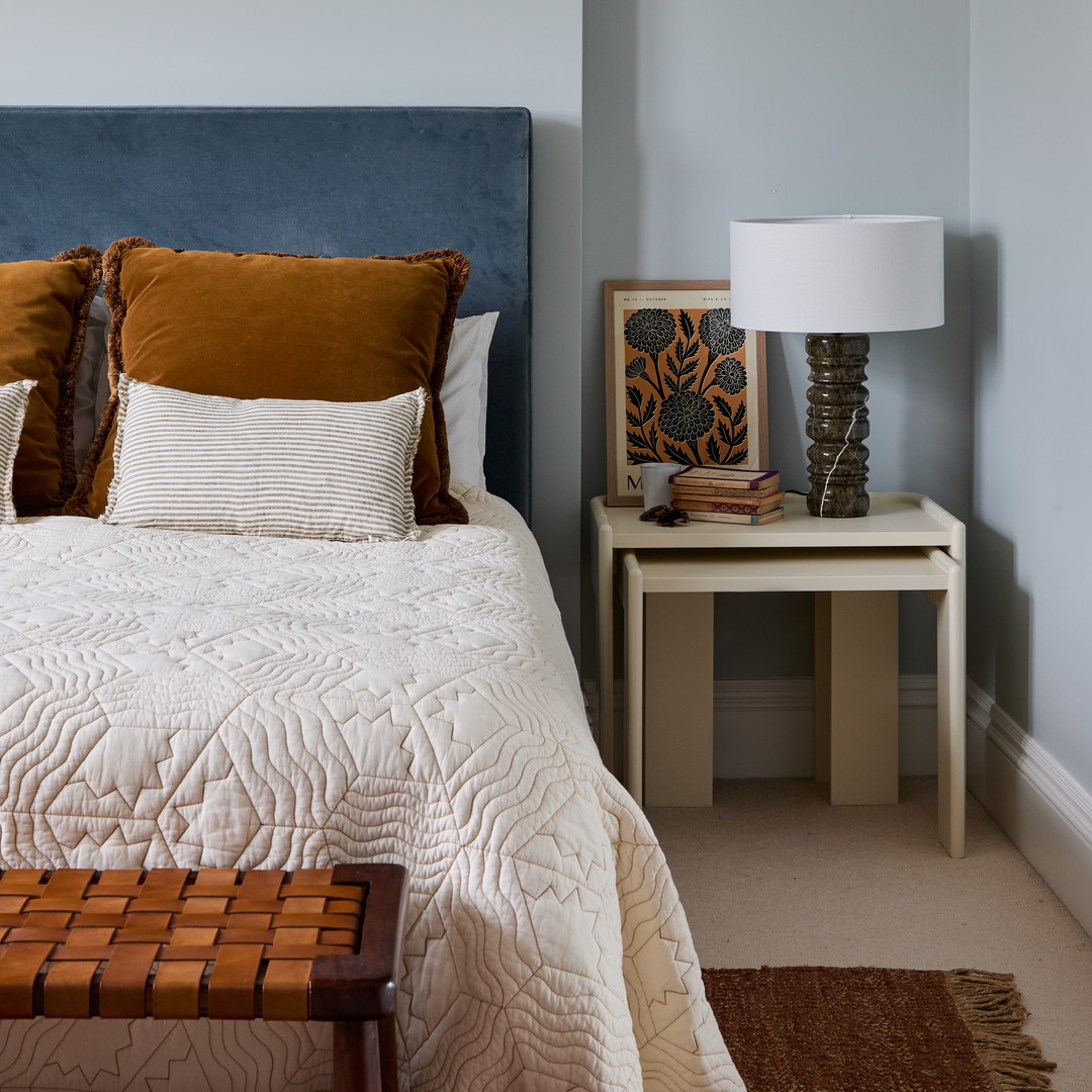 a bedroom with a blue headboard and a white bed