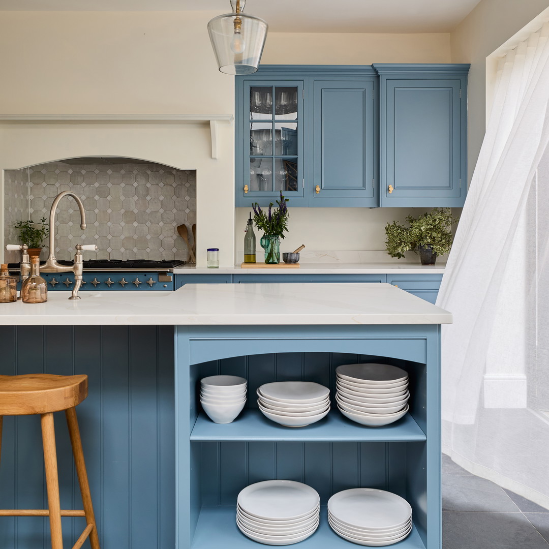 a kitchen with blue cabinets and white plates