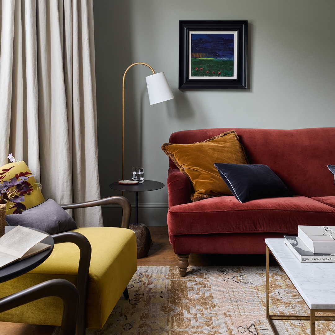 a living room with a red couch and a yellow chair