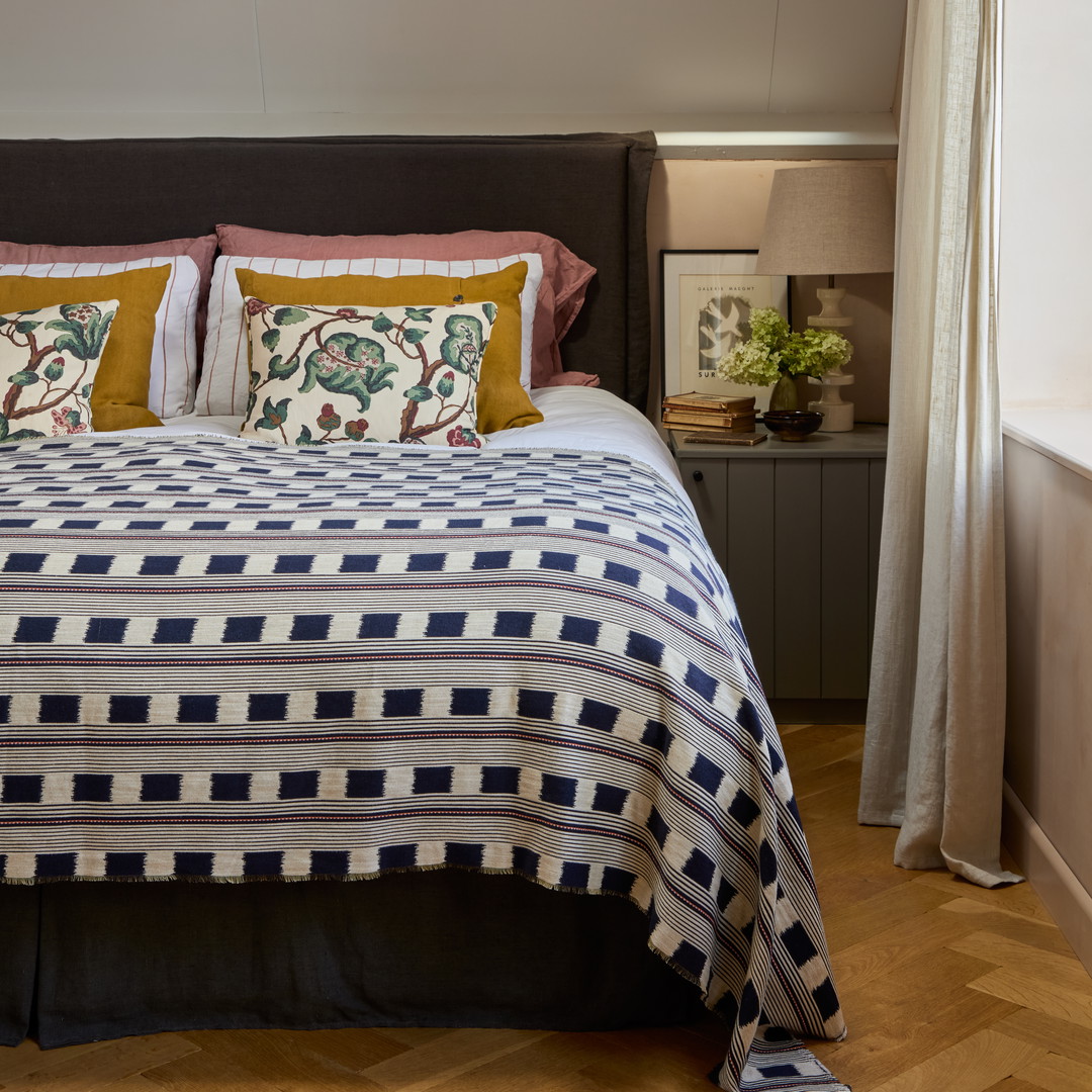 a bed with a blue and white bedspread and pillows