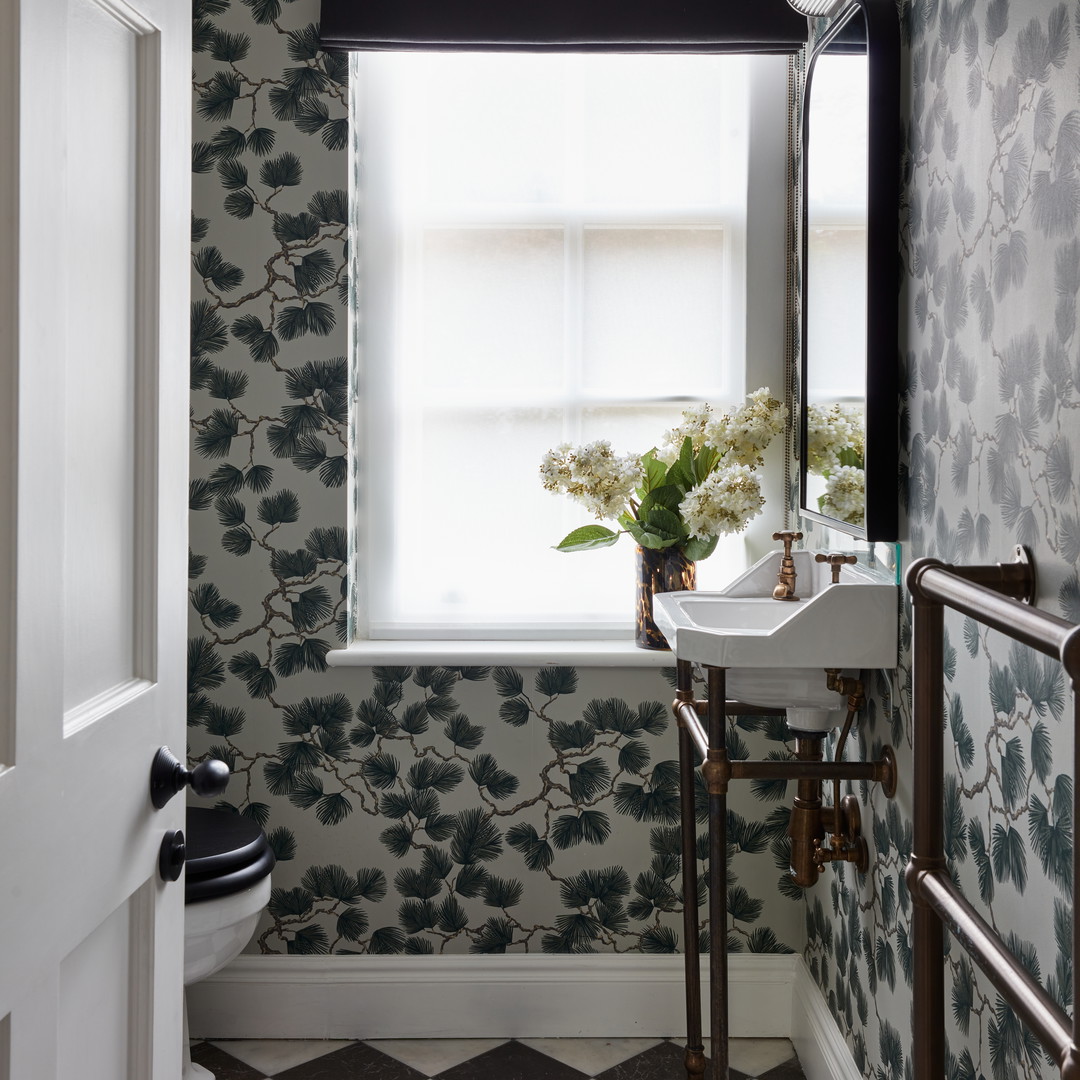 a bathroom with a checkered floor and wall paper