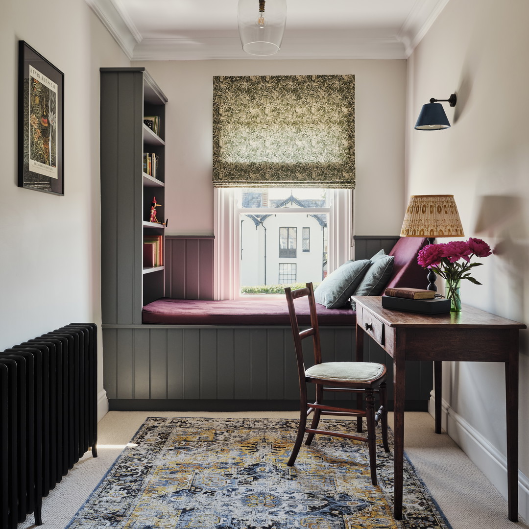 a room with a chair, desk and a window