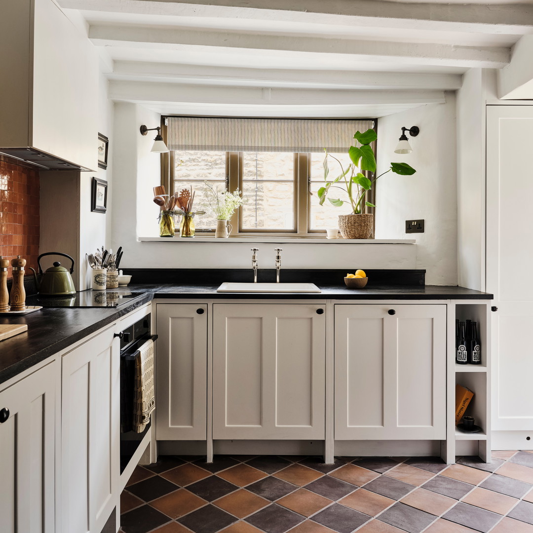 a kitchen with a black counter top and white cabinets