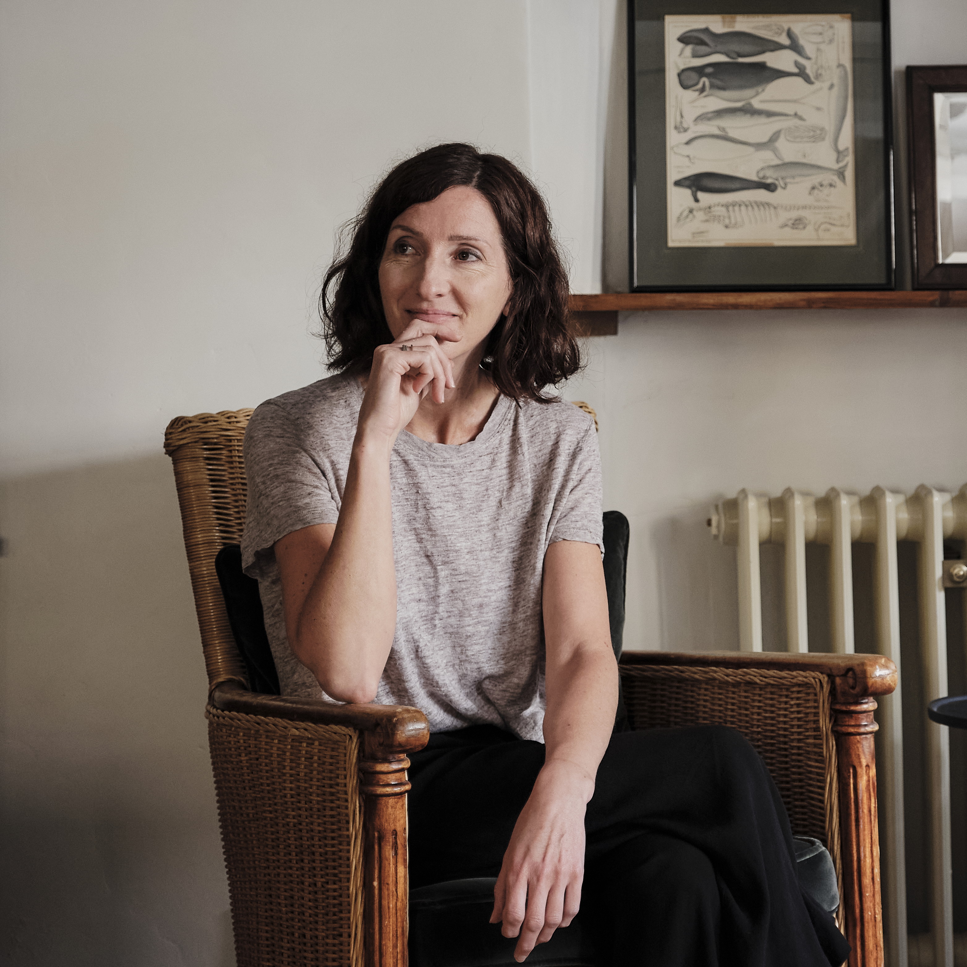 a woman sitting in a chair in front of a radiator