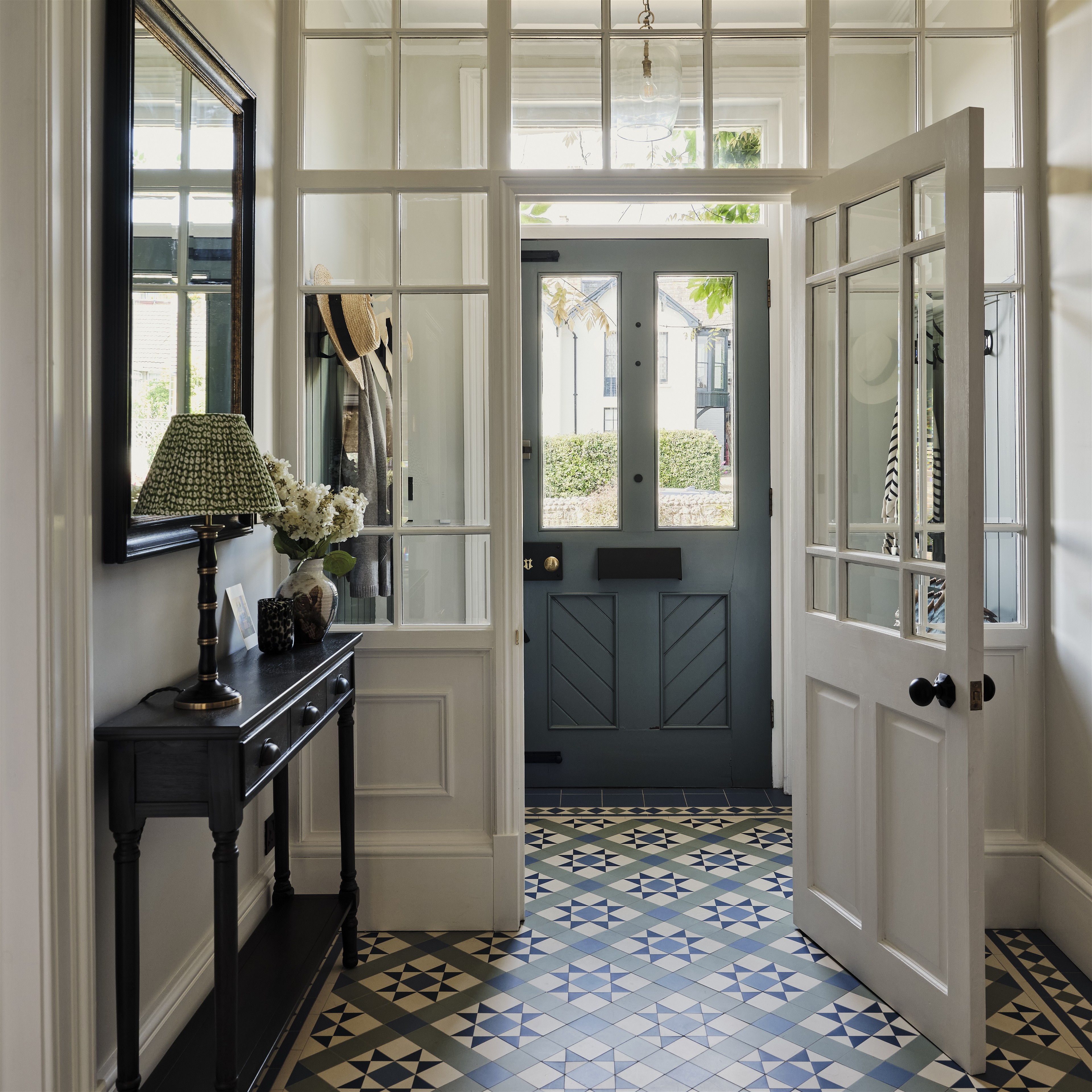 a hallway with a black door and a checkered floor