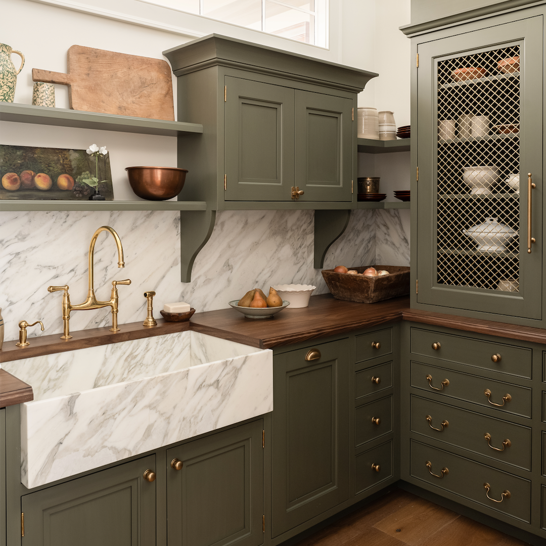 a kitchen with green cabinets and marble counter tops