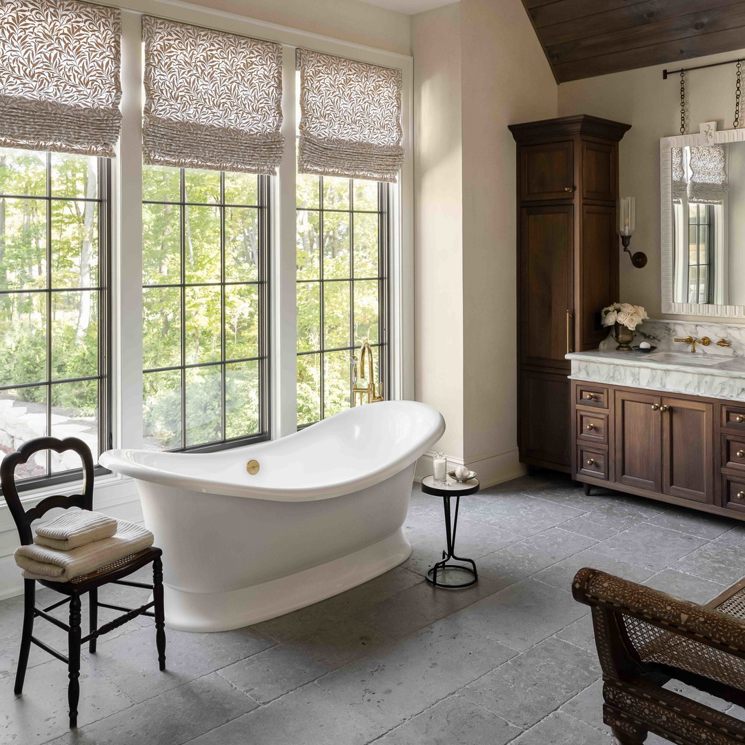 a large white bath tub sitting in a bathroom next to a window