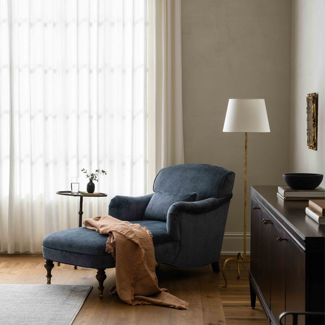 a living room with a chair and a lamp