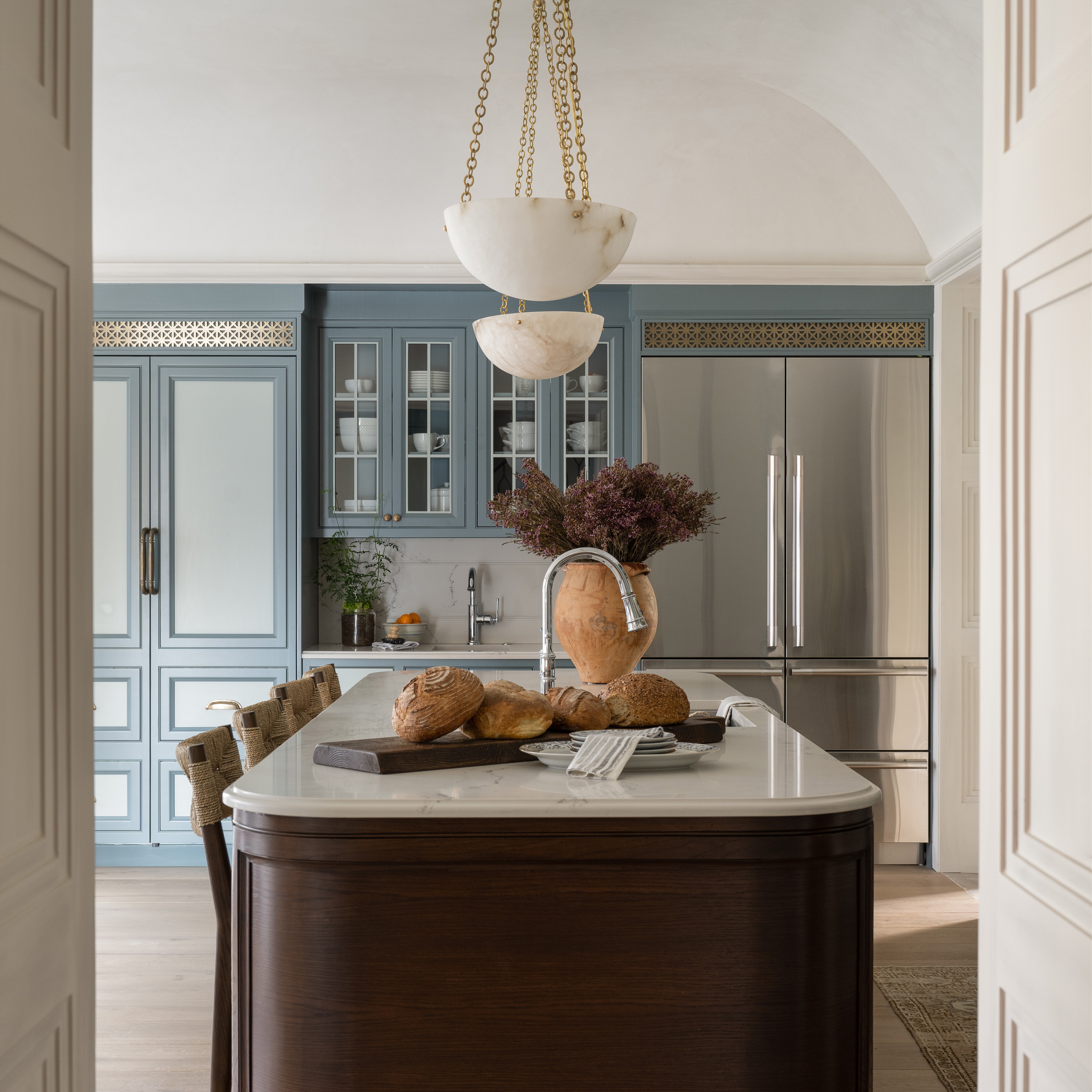 a kitchen with a large island and a chandelier