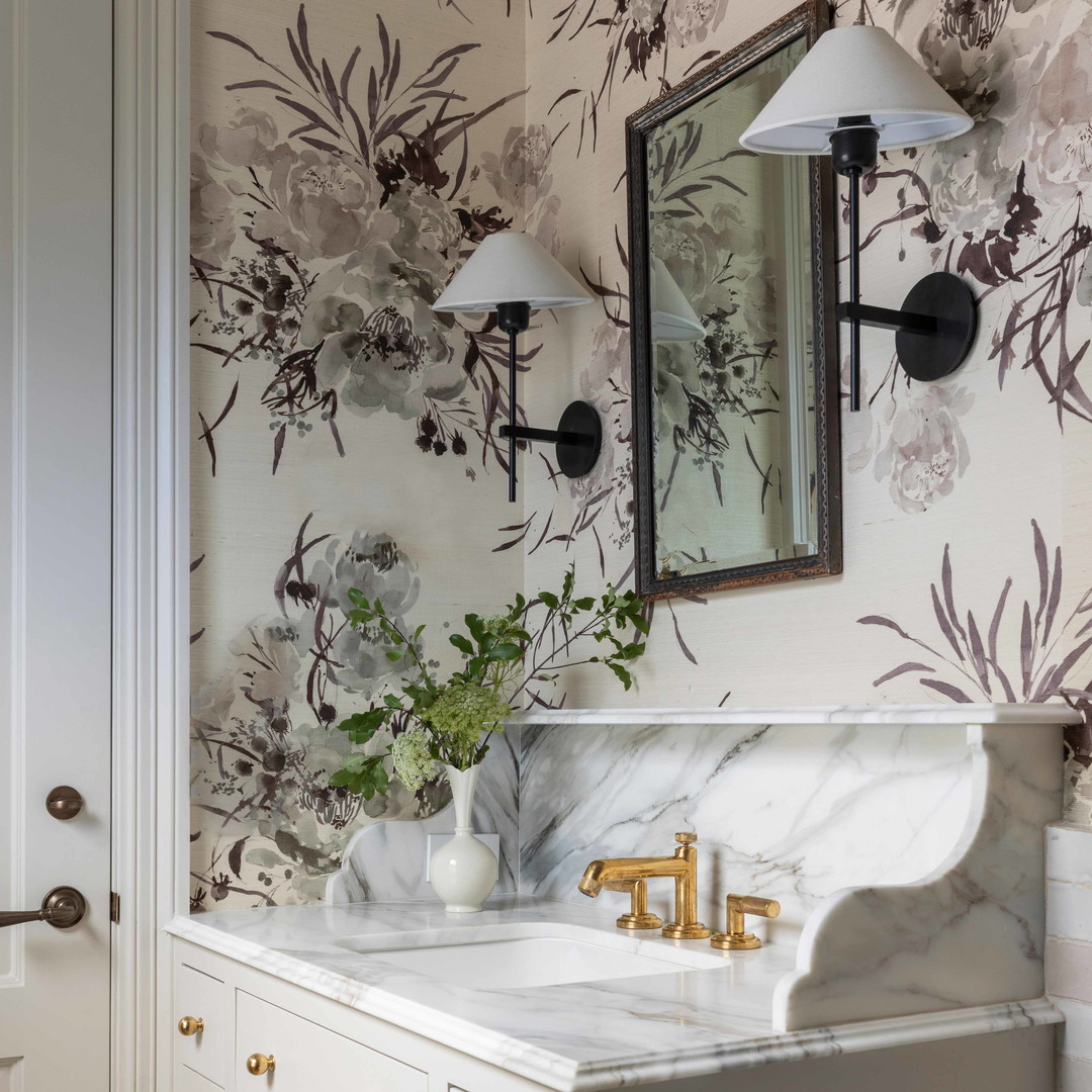 a bathroom with a marble sink and gold faucet