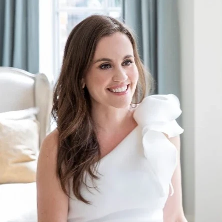 a woman in a white dress sitting on a couch