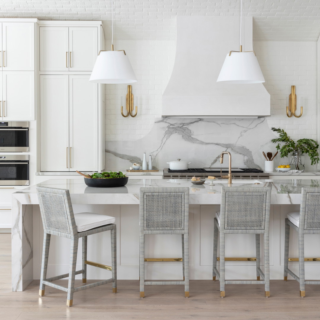 a kitchen with marble counter tops and white cabinets