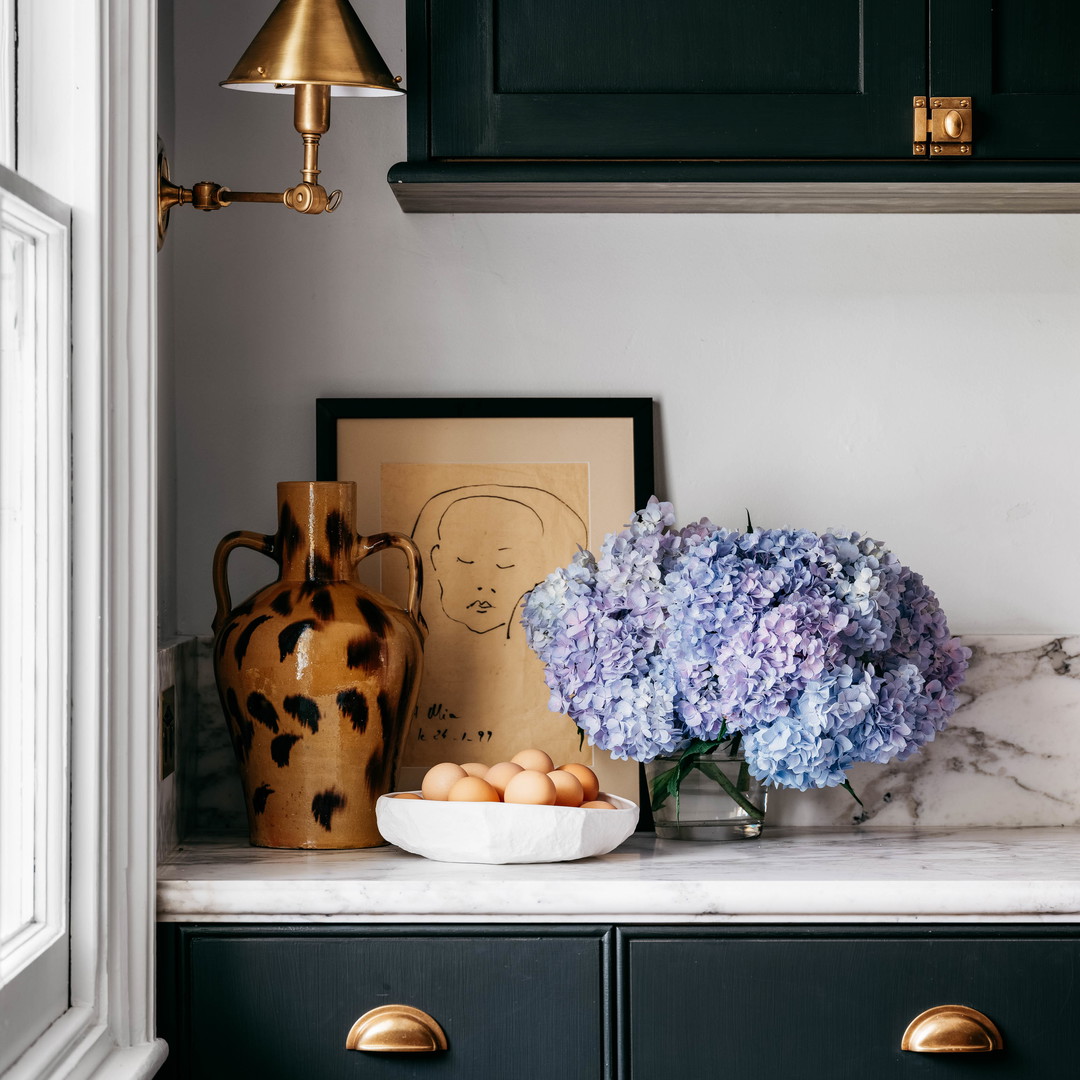 a vase of flowers sitting on top of a counter