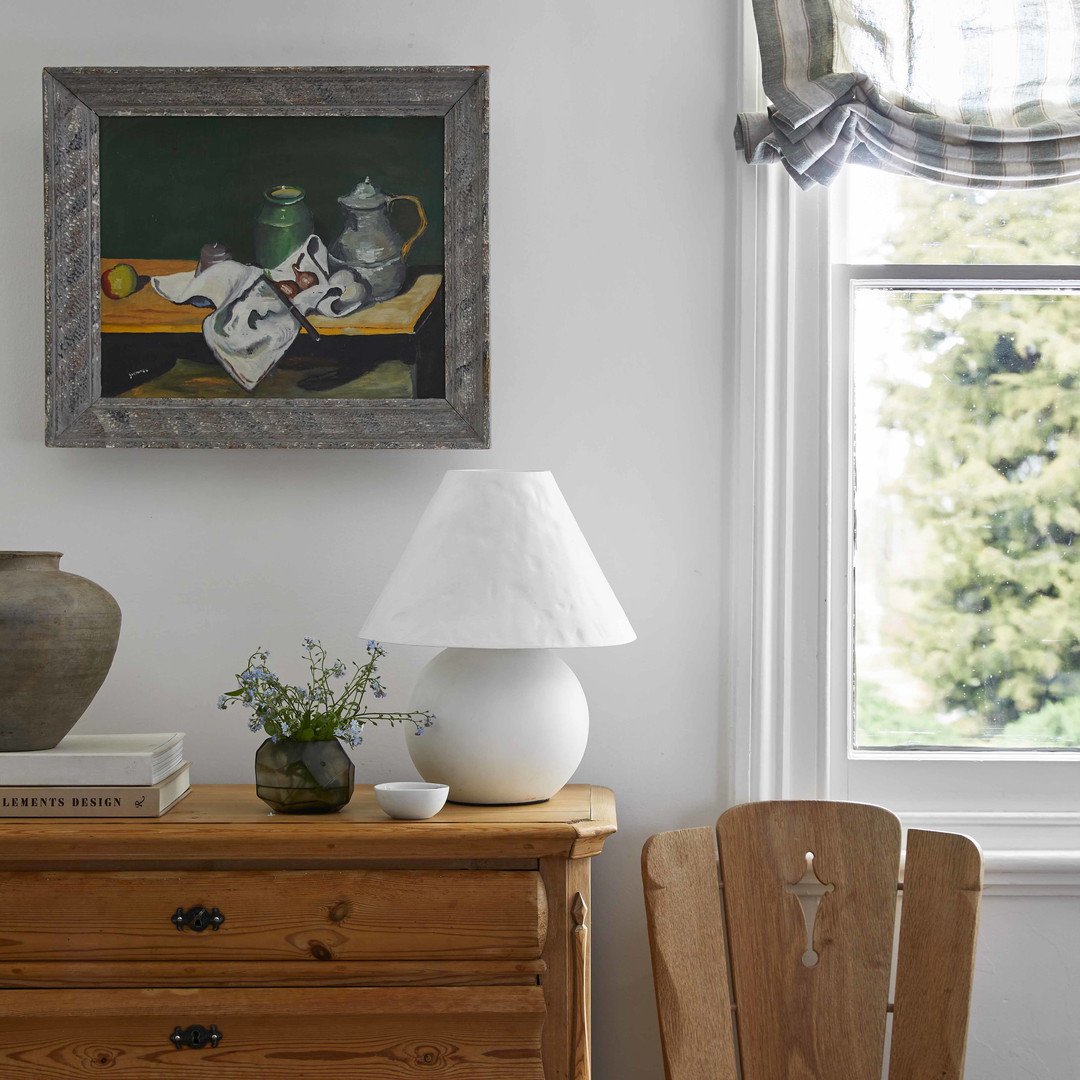 a room with a dresser and a painting on the wall