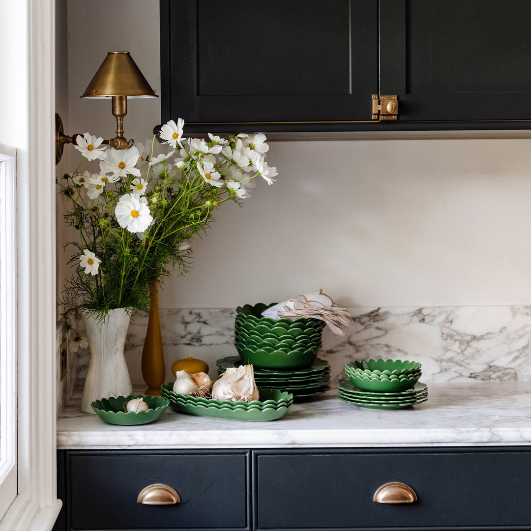a kitchen with a marble counter top and black cabinets