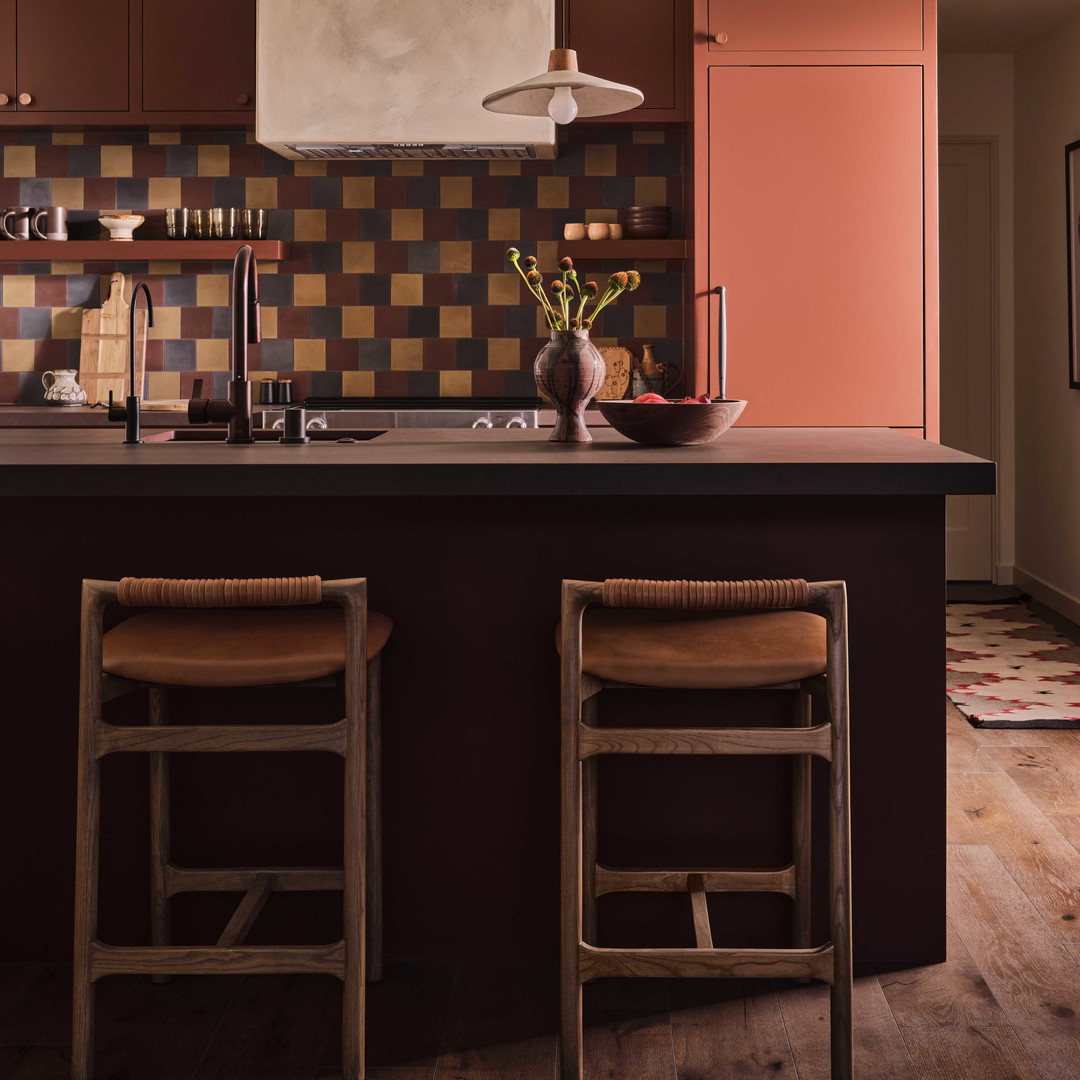 a kitchen with two stools next to a counter