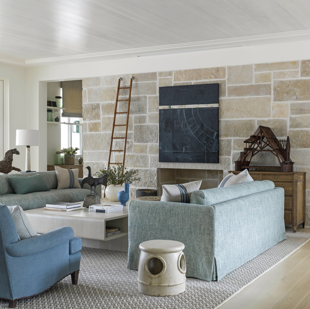 a living room filled with furniture and a stone wall