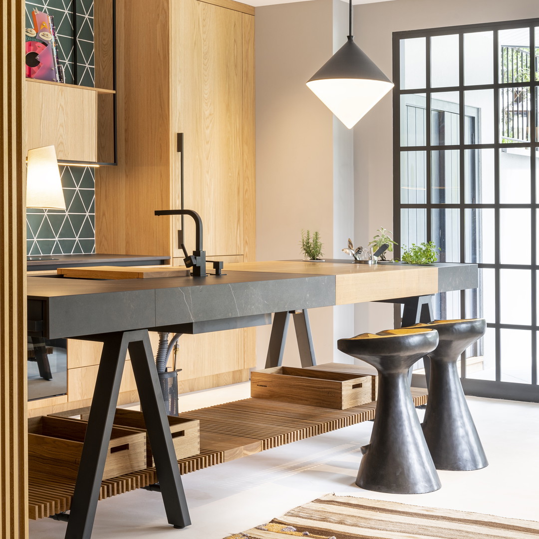 a kitchen with a table and stools in it